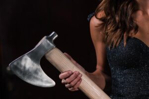 Woman in black dress holding an axe